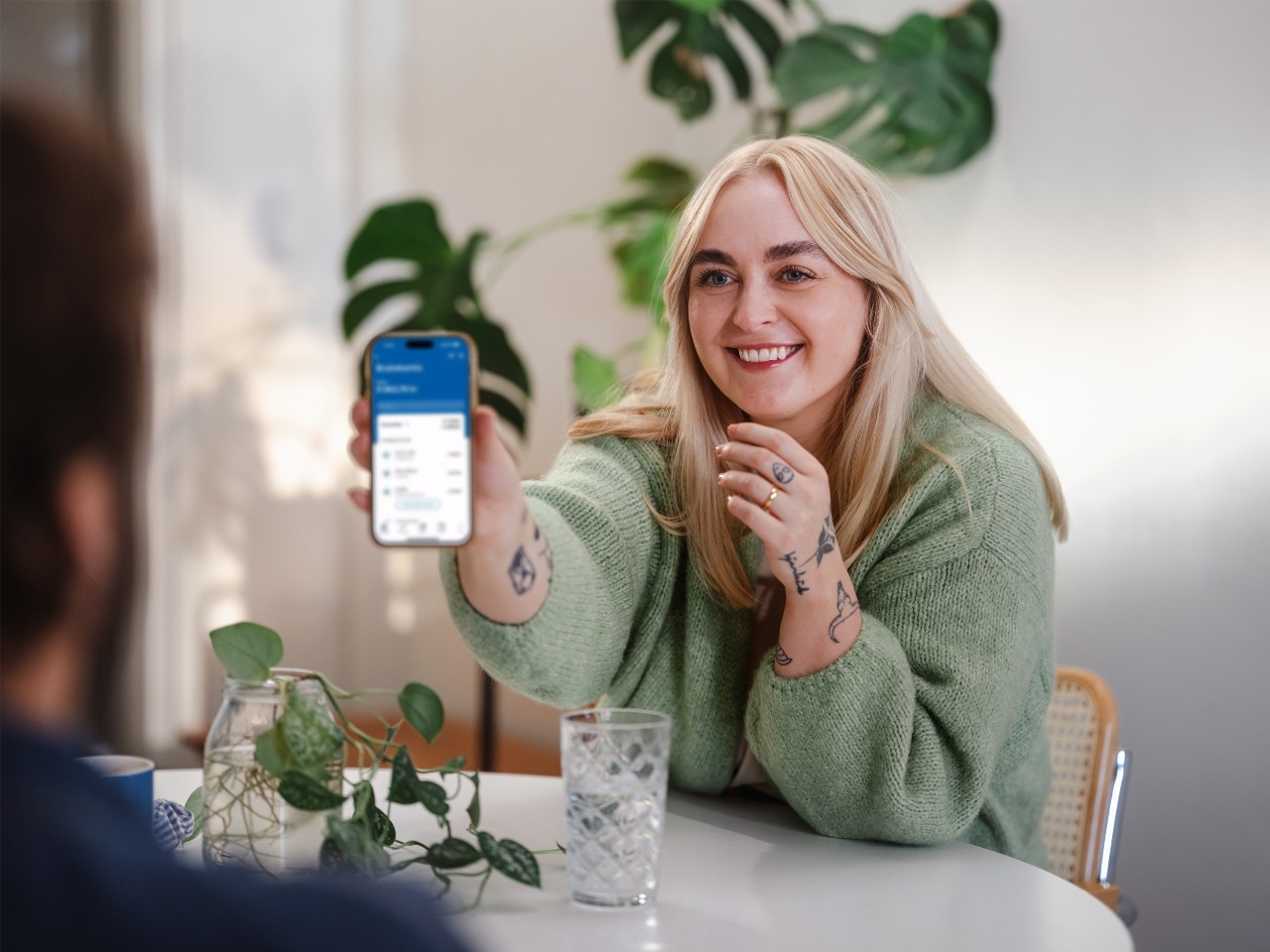 Dame som viser frem Norges beste mobilbank. Foto. 